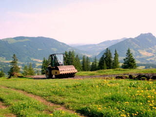 Straßenwalze am Berg: Hier wurde gerade ein Bauweg gewalzt, der von der obersten Kehre des Alpwegs zur Wiedhagalpe weiter zur Bergstation der neuen 6-KSB führt.