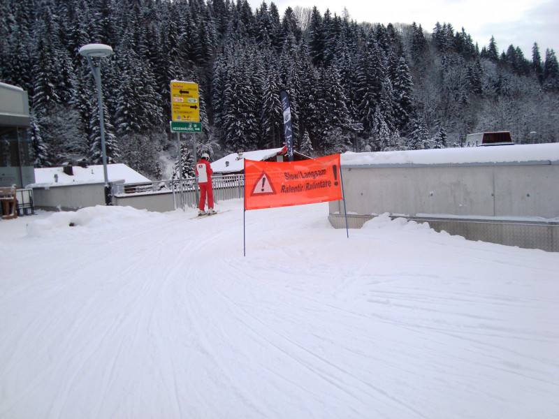Scharf um die Kurve geht's in den Skiweg zur Hausbergbahn. Auch ein Pistenaufsteller steht im Weg. Dadurch hoher Geschwindigkeitsverlust.