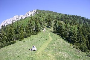 Knapp 5 Gehminuten vom Haus wird der Gipfel zum ersten Mal sichtbar. Hier trennen sich die Wege: der Normalweg geht rechts, der Klettersteig links unter die Felsen.
