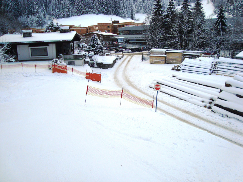 Nicht mehr zeitgemäß. Über eine Straße dann der Straße entlang über eine Brücke. Gefahr für die Ski!