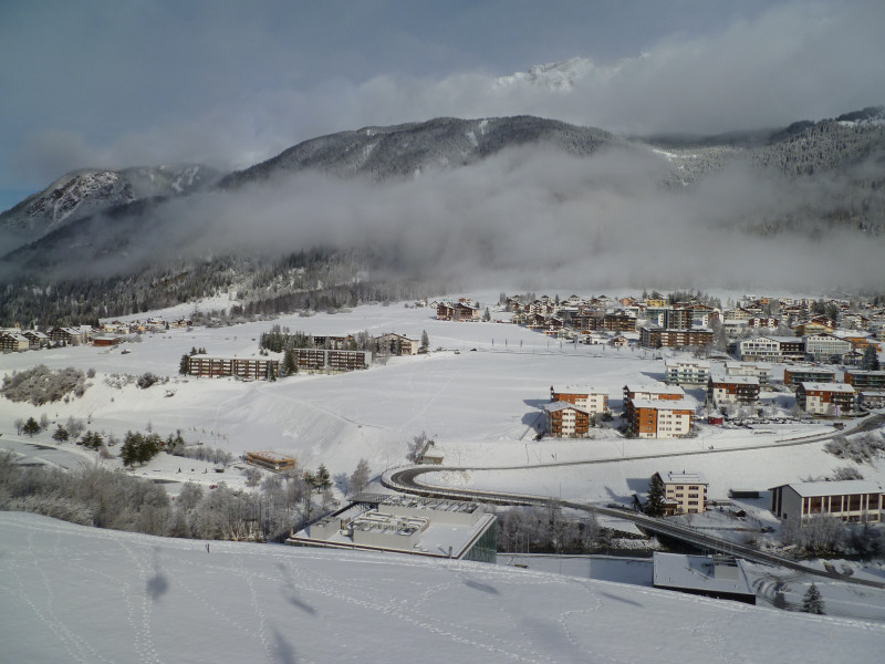 13:33 Uhr: Unterdessen bin ich auf der 4er Sesselbahn, welche am 31. März 2019 nach 32 Jahren in den Ruhestand gehen wird und durch eine zweite 10er Gondelbahn ersetzt wird. Auf der Wiese in der Mitte des Bildes, links vom Surses Alpin, sollen zudem ein Mövenpick-Hotel und ein Ferienresort, ähnlich jenem in Brigels, entstehen.