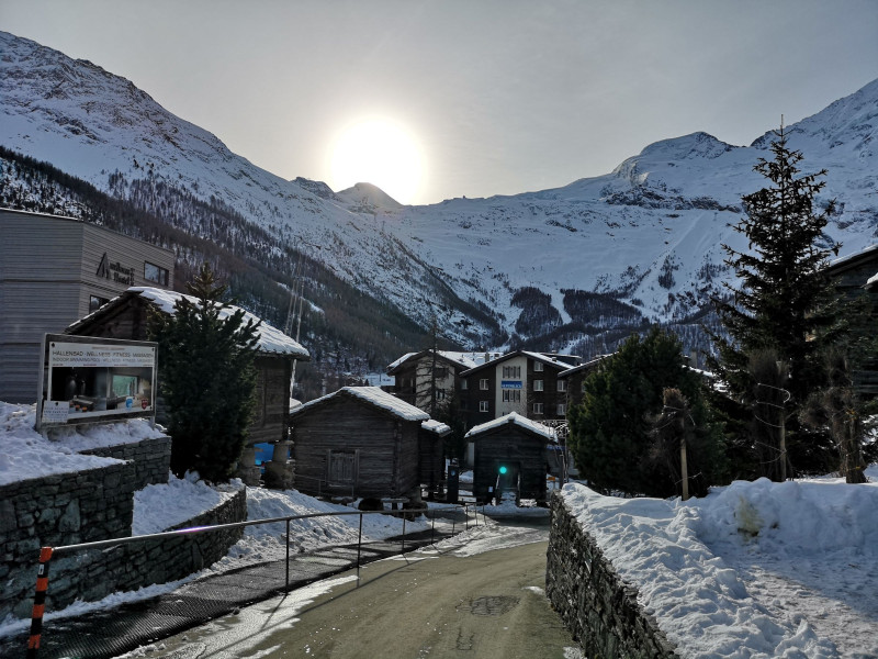 Erster Blick vom Busterminal ins Skigebiet von Saas-Fee. Bereits sind die ersten zwei 4000er in Sicht: Das 4027 m hohe Allalinhorn vor der Sonne und der nächste Gipfel rechts davon, der 4206m hohe Alphubel.
