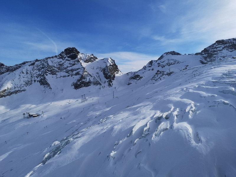 Blick über den Gletscher zum Bereich um Morenia mit Egginer und Egginerjoch dahinter. Bei der 6-KSB Morenia werden die Sessel nun auch ausgaragiert.