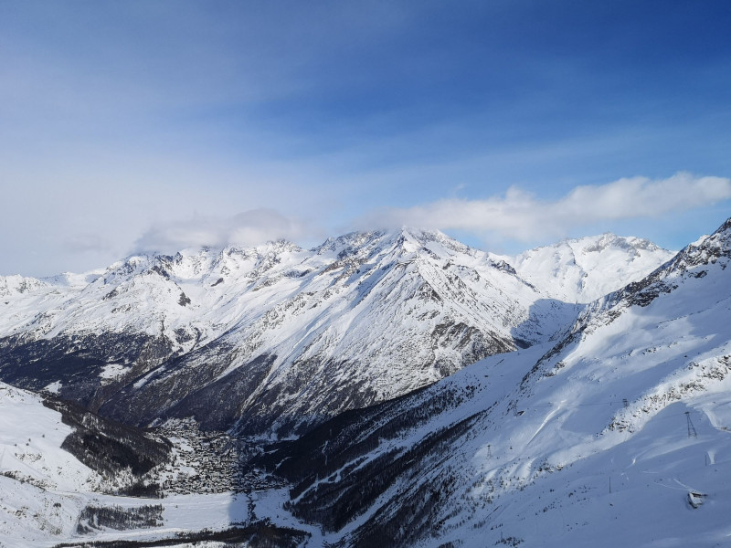 Blick übers Dorf auf das sonnige Skigebiet von Saas-Grund, das ebenfalls über eine sehr imposanten Gletscher verfügt. Die Spitzen der nächsten 4000er, Weissmies (4017m, rechts) und Lagginhorn (4010m, links) verstecken sich noch in den Wolken.