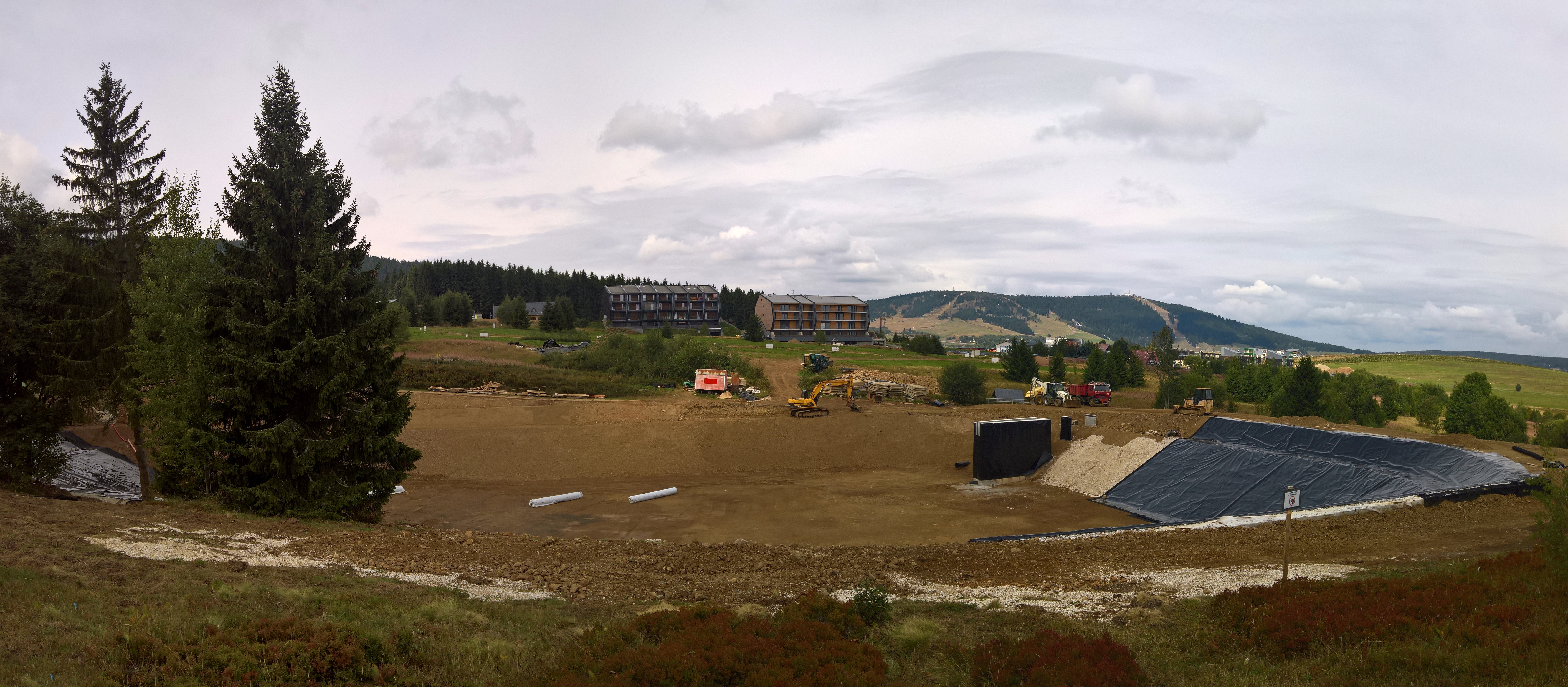 Speichersee im Gelände in voller Ausdehnung mit aktuellem Bautenstand