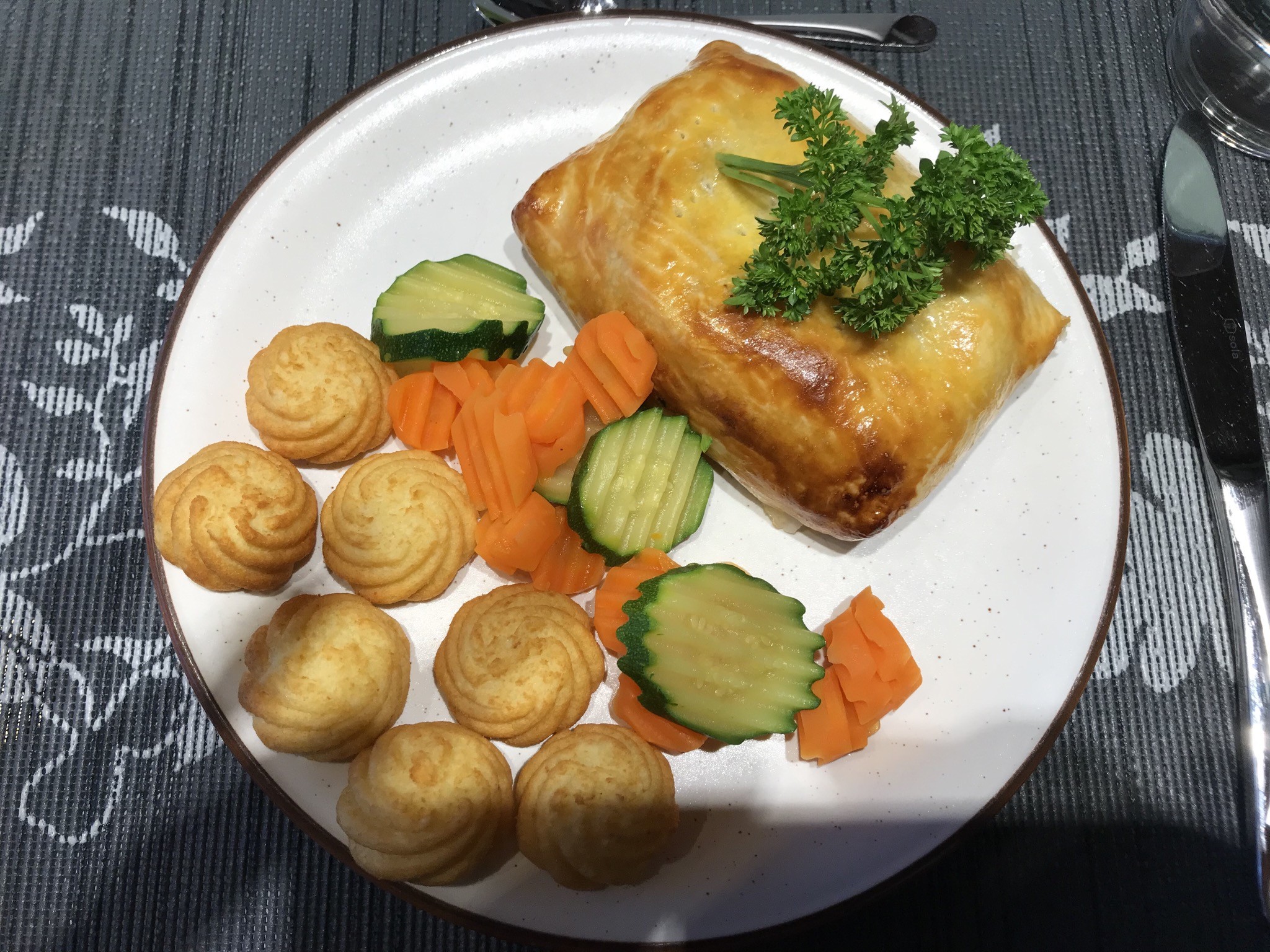 Ein Schweinefilet im Teig mit Pommes Duchesse und Gemüsegarnitur