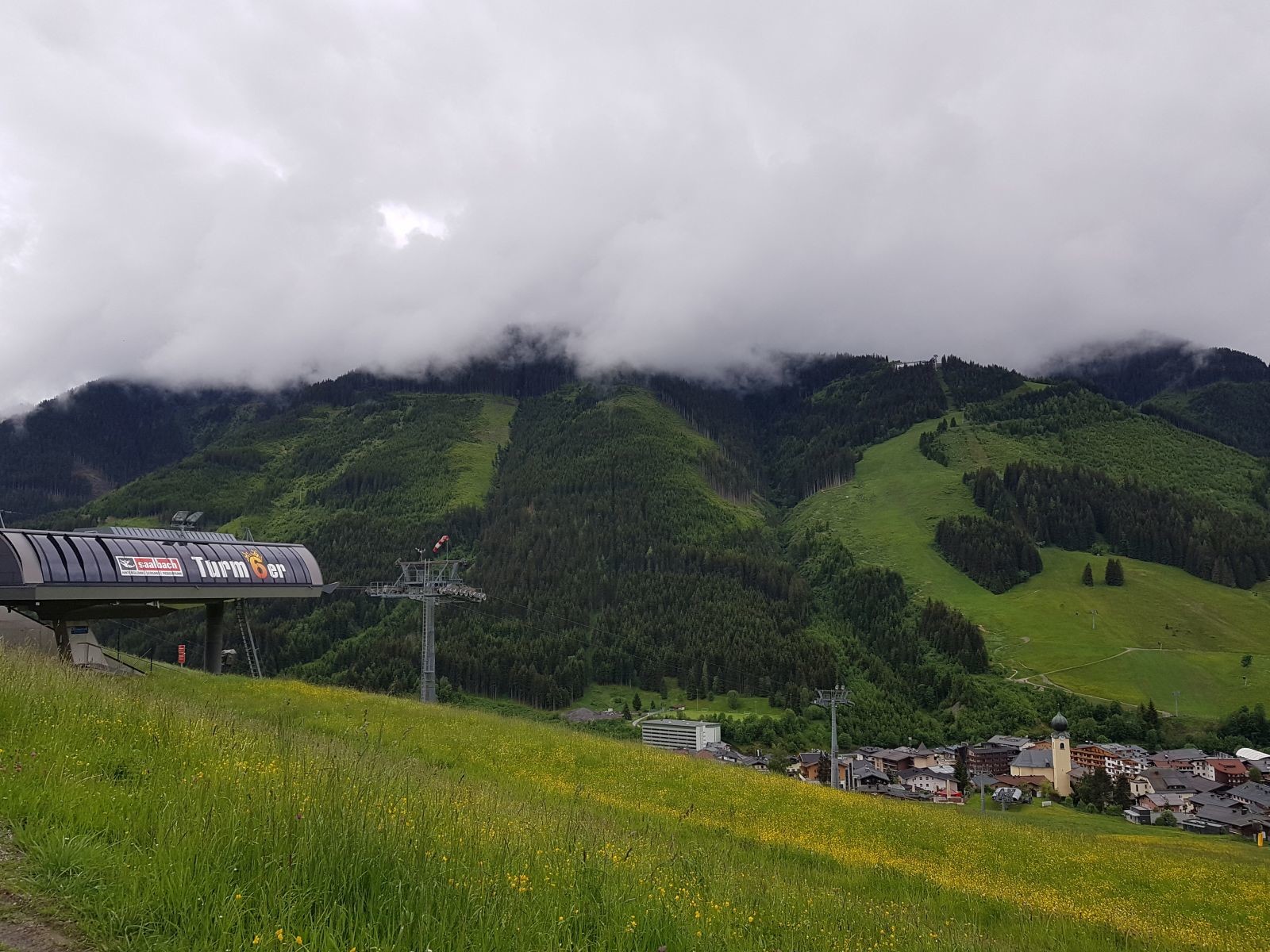Um 12 Uhr starteten wir die Wanderung direkt vom Hotel im Saalbacher Oberdorf. Hier an der Turmwiese mit dem Turm 6er oberhalb von Saalbach.
