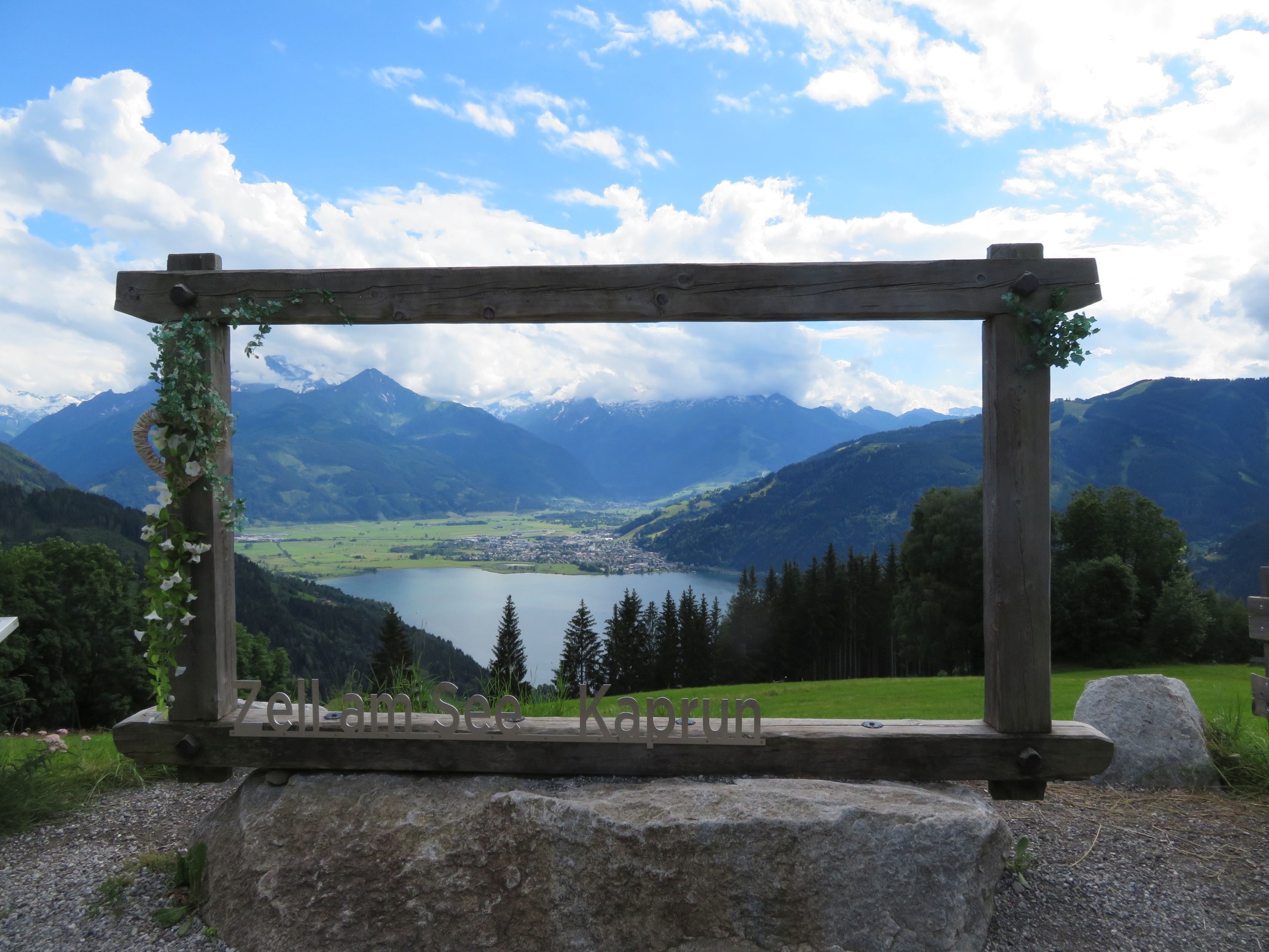 Blick von der Jausenstation durch den Rahmen in Richtung Schüttdorf und das dahinter in Wolken verborgene Kitzsteinhorn.