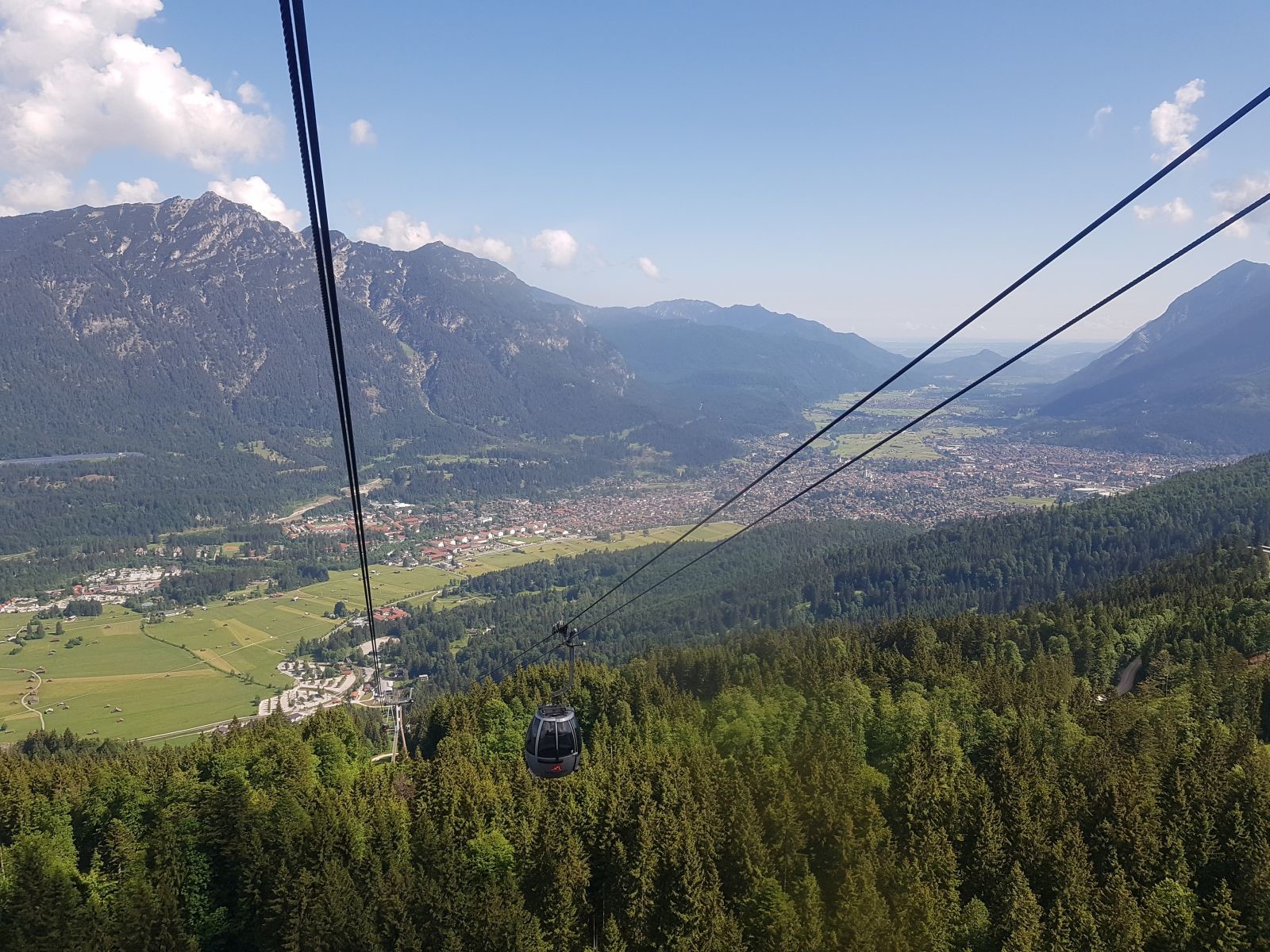 Mit der Kreuzeckbahn geht es nach oben. Auch wenn sie mir persönlich nicht so taugt, ist das eine besondere Anlage. Diese 2S-Bahnen sind äußerst selten. Dennoch fand ich den Kabinentyp schon immer ziemlich unpraktisch und unvorteilhaft. 15 Personen passen da nie im Leben rein und generell hängen imo viel zu wenige Kabinen dran (Man muss im Tal auf das nächste FBM fast 30 Sekunden warten.). Der Ausblick ist dann aber für so eine Bahn typisch traumhaft ;-)