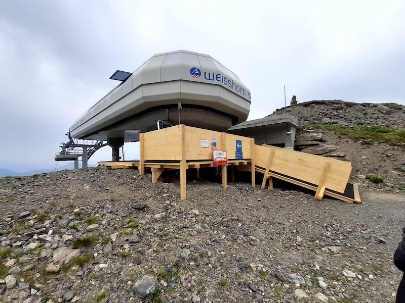 Bergstation. Vom oberen, interessanteren Teil der Trasse habe ich leider keine Bilder. Dies, weil es plötzlich zu regnen begann und wir die Haube schlossen. Jeder zweite Sessel hat die Haube behalten.
