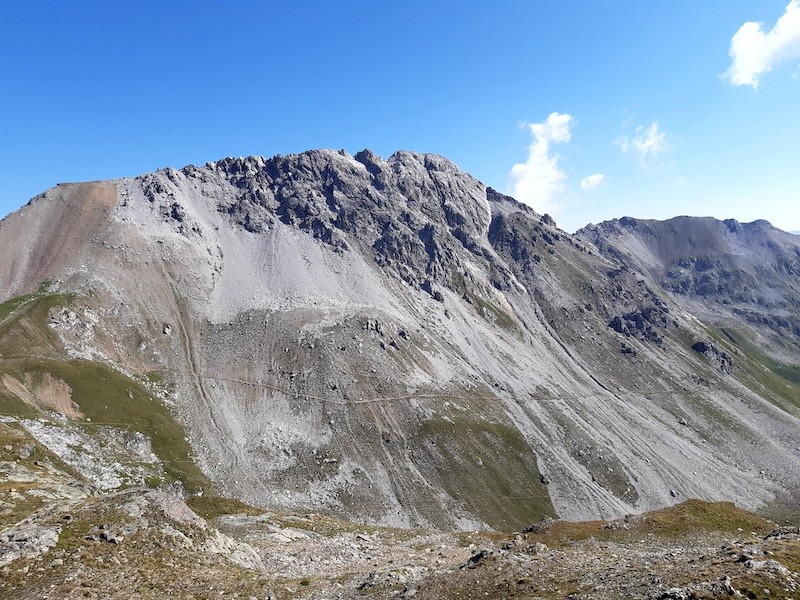 Der Weg, welcher auf der gegenüberliegenden Hangseite zu sehen ist, werden wir im Verlaufe der Tour befahren. Der Trailverlauf ist in Wirklichkeit dann doch etwas weniger extrem, als dass man es aus dieser Perspektive erahnen würde. Dennoch benötigt das Befahren Konzentration!