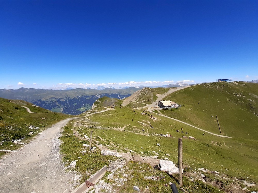 Sattelhütte und Bergstation der 6KSB Brüggerhorn. Links an der Hütte vorbei, entlang des Kiesweges, führen im Winter die Pisten 11 und 12. Auch mit dem Bike fuhren wir mehr oder weniger entlang der Piste 11.