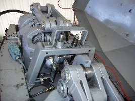 Die Wage. Fällt der Zug des Zugseiles ab, wird über das Kniegelenk der Balken mit einer Feder hochgedrückt und die Klinke fällt runter.