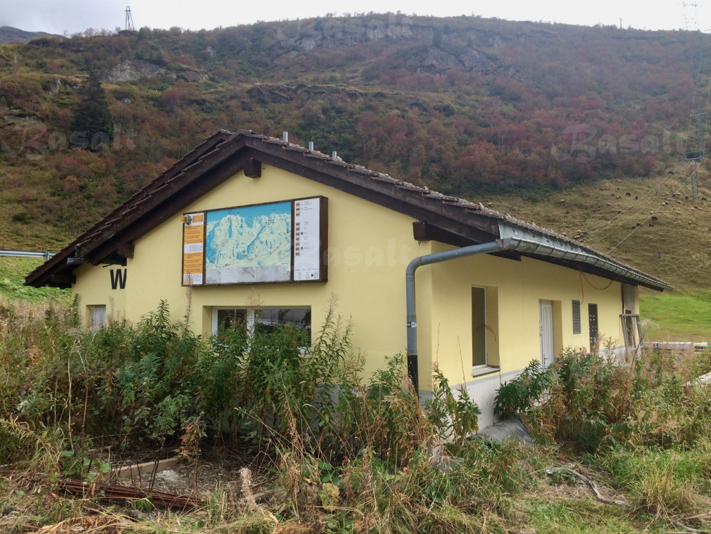 ^ Blick vom ehemaligen Parkplatz auf die einwachsende Talstation.