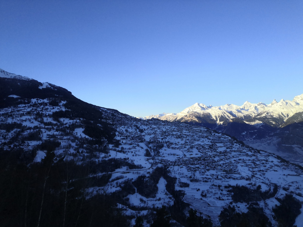Blick auf das schattige Nendaz während der Postautofahrt nach Veysonnaz.