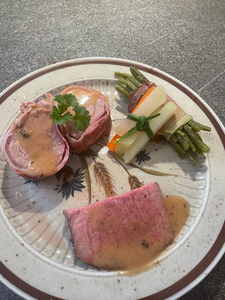 Hauptgang: sous vide gewartet Schweinelendchen im Speckmantel und Semmerrolle vom Rind niedergegart mit Wacholder- Cognacrahmsauce; dazu Bohnen- und Gemüsebündel, Spätzle und Kartoffeltaler