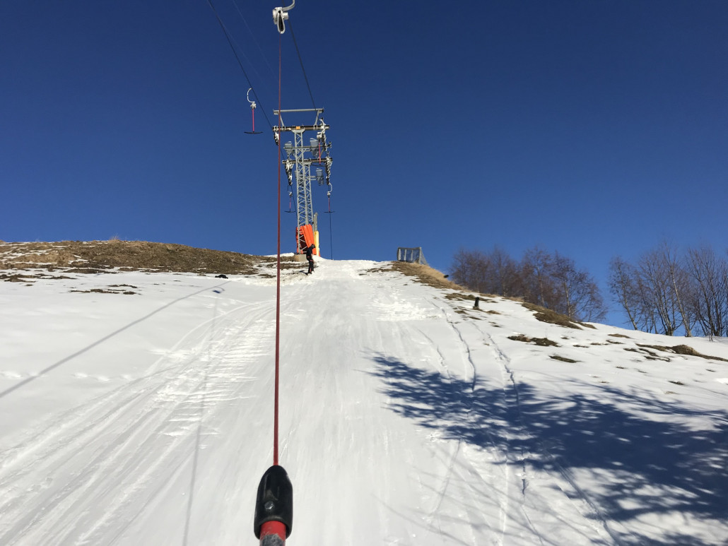 Am sonnigen Verbidungslift wird per Schaufel Schnee eingebracht