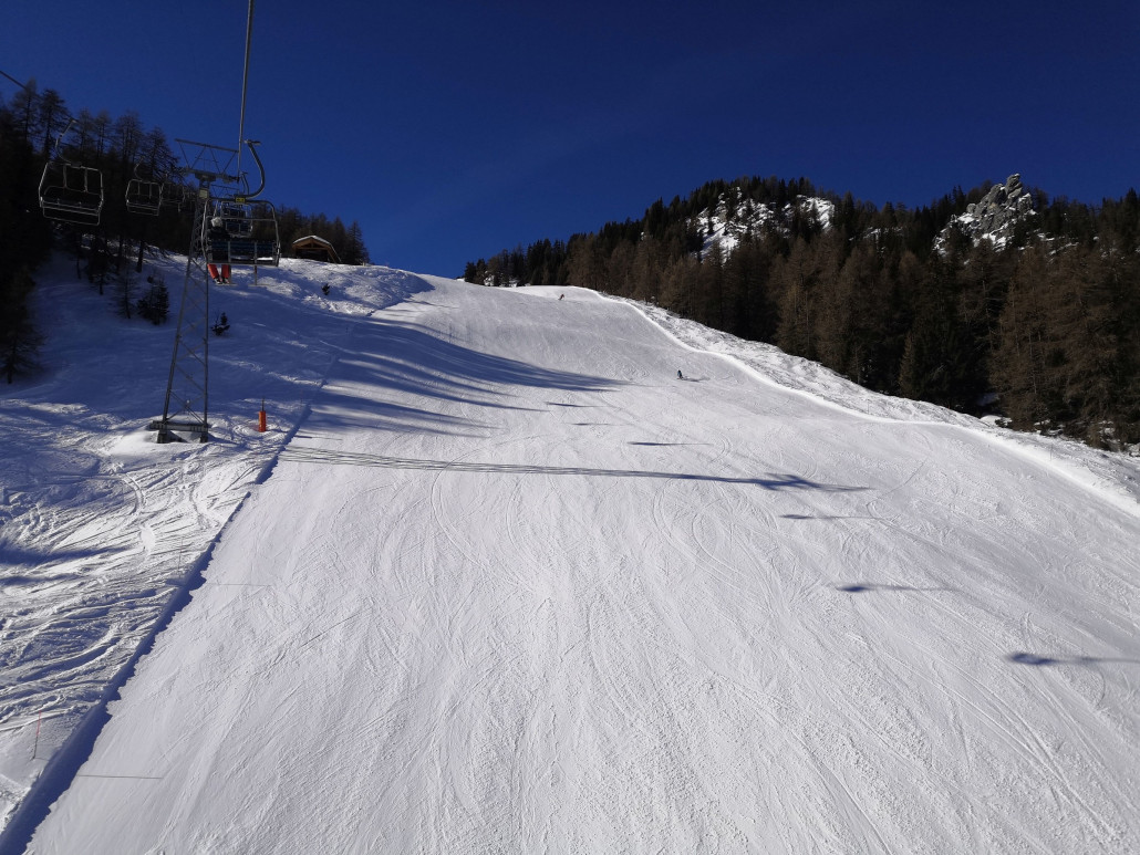 Leere schwarze Piste unterhalb der Sesselbahn