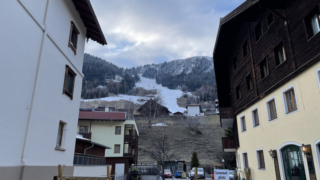 Sicht vom Ort nach oben. Hier lag nur bei der Ankunft ein bisschen Neuschnee, aber die Temperaturen sind zu hoch, als dass es hier unten liegen bleibt. Oben allerdings schön weiß inklusive weißer Nadelbäume!