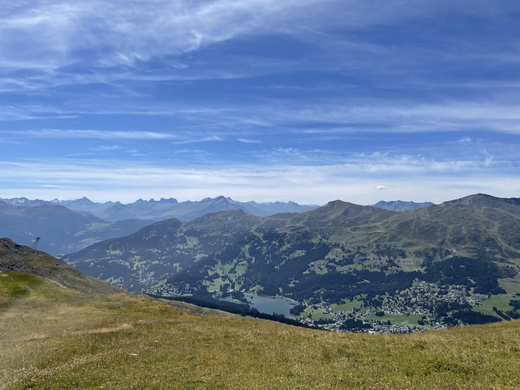 Im Winter zweigt an dieser Stelle die Weisshornpistze nach links ab und verläuft auf dem hier im linken Bildrand zu sehenden, sattgrünen Wiesenabschnitt um den Hügel herum.