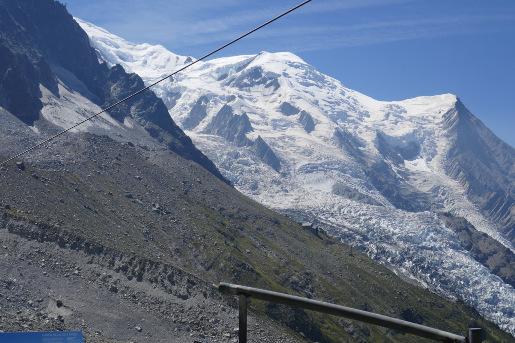 Aguille du Gouter, davor der Bossons Gletscher. Am grünen Berghang in der Mitte sind die Bergstation sowie ein paar Stützen der ersten nie fertiggestellten AdM PB zu sehen.