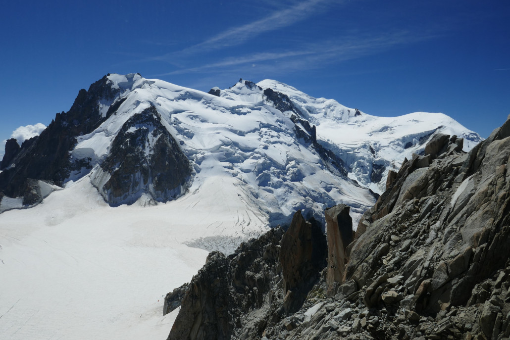 Erster Blick auf den Mont Blanc. Der Gipfel (4808m) ist mittig rechts zurückgesetzt. Durch den mächtig abfallende Tacul-Gletscher in der Mitte führt die Hauptroute zum Mont Blanc.