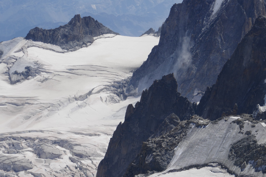 Hinter dem kleinen Gipfel in der Mitte ist ca. eine halbe Minute vor Entstehung des Bildes eine Schutt- und Eislawine abgegangen. Man kann noch die Staubwolke der Lawine und den Auslaufbereich der Lawine links mittig unten auf dem großen Gletscher sehen. Der Abgang machte sich durch ein lautes und langes Donnergeräusch wie bei einem Gewitter bemerkbar.
