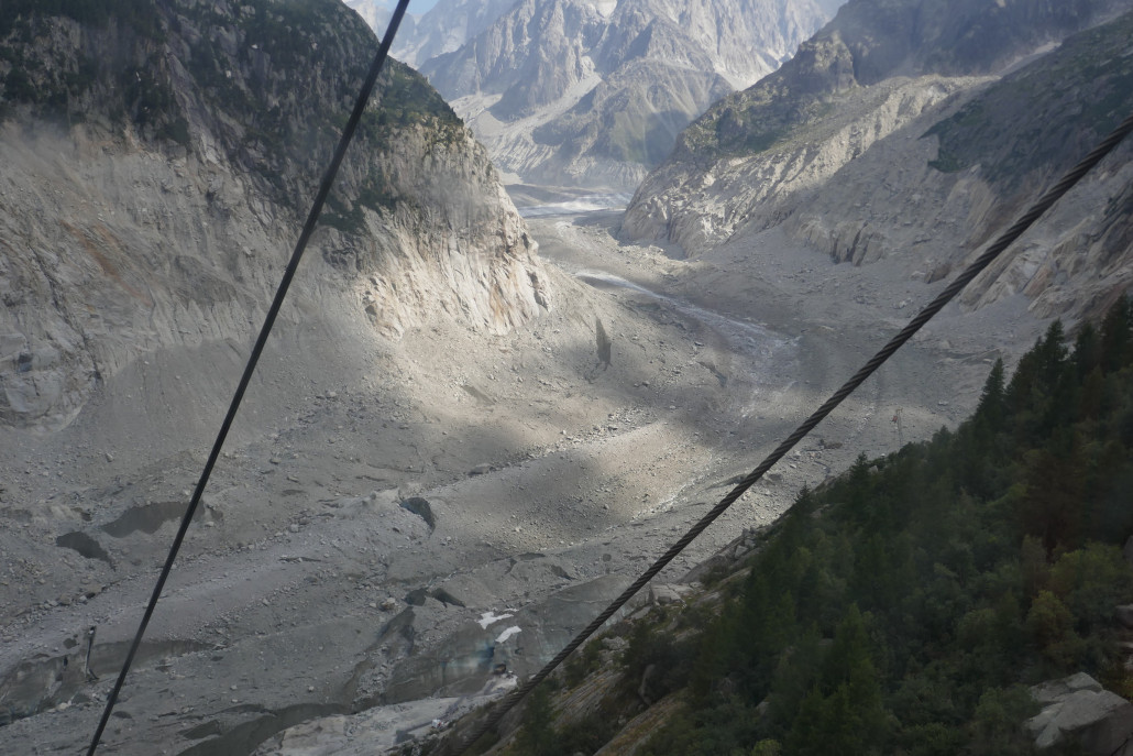 Mer de Glace im unteren Vallée Blanche. Auch hier sind die Schutt- und Gesteinsmengen auf dem Gletscher gut sicht- und oftmals auch hörbar. Man hört ein dauerndes „Rieseln“ von kleineren Steinen auf den Gletscher und alle paar Minuten gehen irgendwo größer Brocken mit einem grollenden Geräusch auf den Gletscher ab. <br />Die Route von der Aguille du Midi kommt hinten rechts aus dem Tal und führt auf dem Gletscher bis zur EUB, bzw. bis zur langen Treppe die zur G-EUB führt.