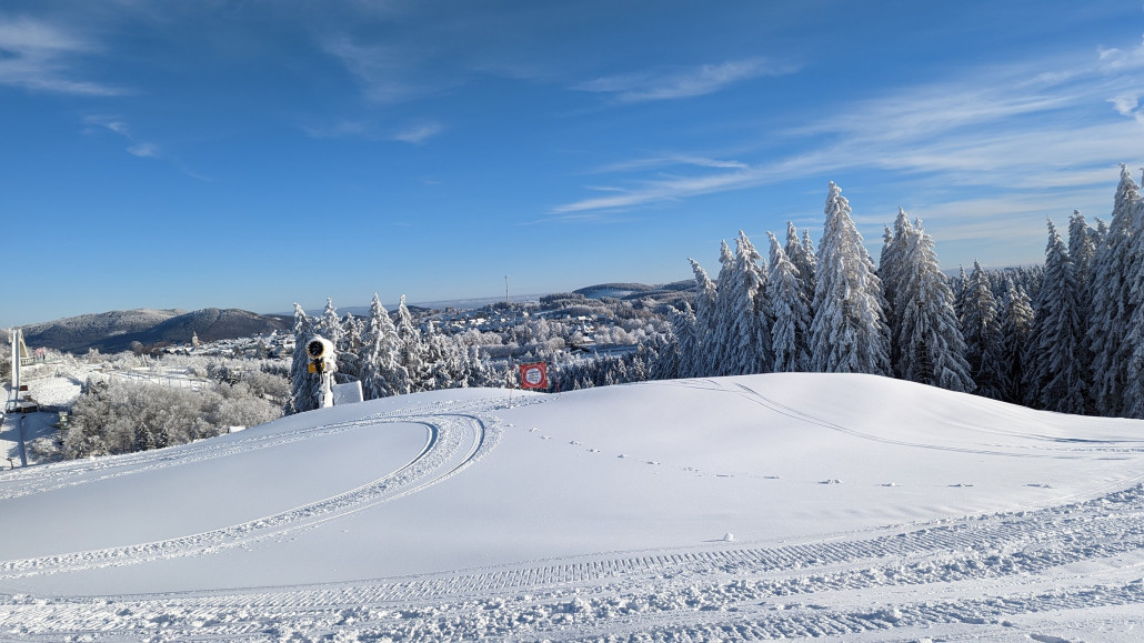 Sicht auf die Abfahrt am QJ durch Beschneiungsberge versperrt.