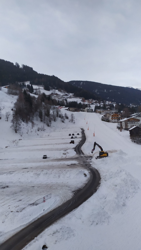 Der Parkplatz war noch wenig gefüllt. Der Bagger schaufelte Schnee auf einen LKW, möglicherweise wurde der Schnee zur Rodelbahn verfrachtet.