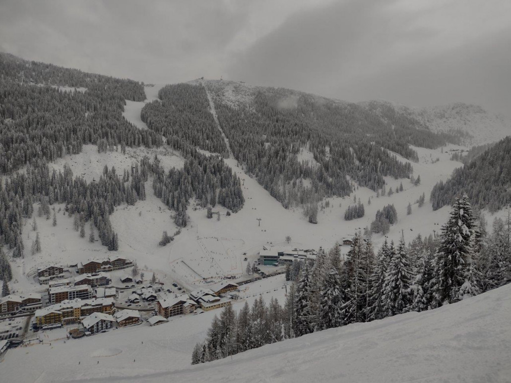 Blick auf Zauchensee und die gegenüber verlaufende 6KSB-B Tauernkarbahn und die schwarzen Piste Nr. 10. Diese Bahn war vormittags außer Betrieb, laut Auskunft des Liftpersonals aufgrund eines Masseschluss auf einer Stütze resultierend vom nassen Neuschnee.