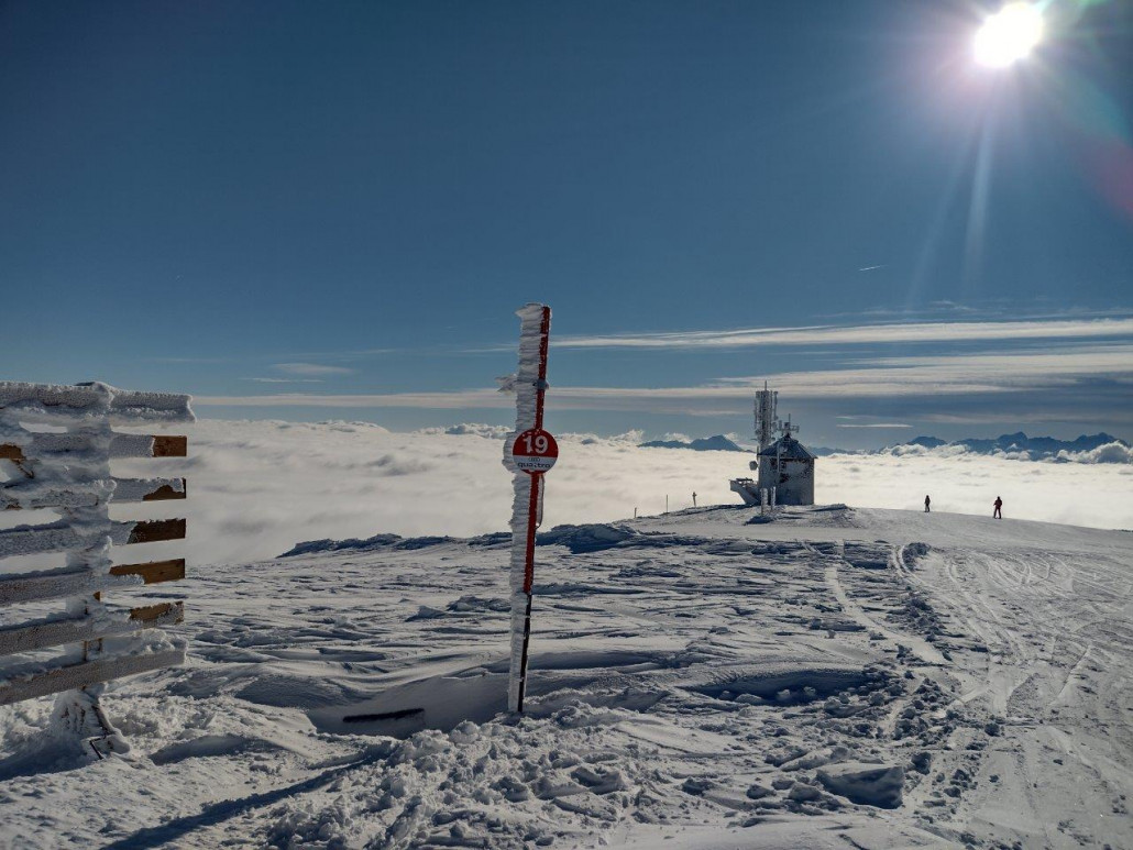Eisverkrustetes Pistenschild und im Hintergrund der Deutsche Turm.