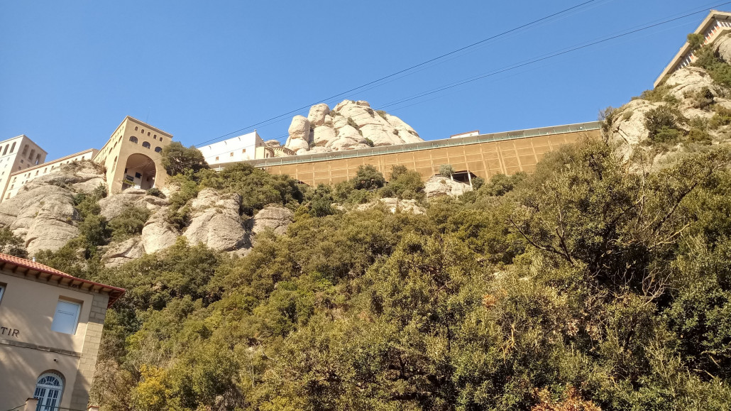 Blick nach oben auf dien Gebäudekomplex, die Matten decken eine Bausünde ab. Vor die historischen Bögen wurde eine Beton-Stahl-Konstruktion gesetzt die an den einsehbaren Teilen für wahres Augenleiden sorgt.