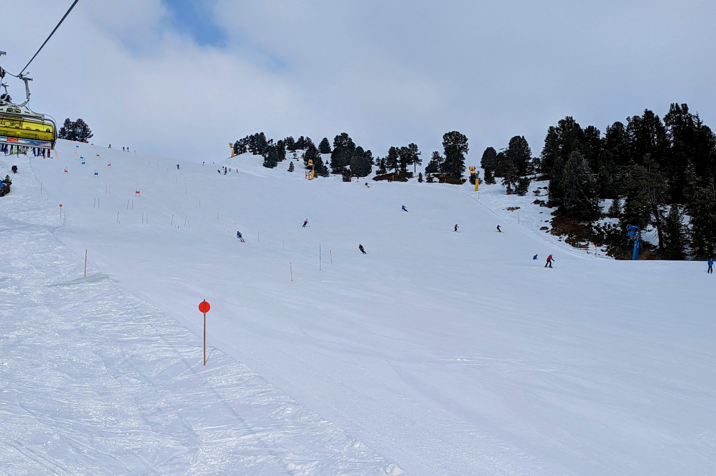 Piste unten am Kristall-Express. Bin hier heute gleich zu Anfang gefahren, weil dieser Pistenabschnitt in der Sonne sonst schnell schlapp macht. Um die Zeit noch wenig Andrang. Ein Teil der Piste für Skiclubs gesperrt, was hier aber nicht stört. Schade dass es zwischen dem oberen breiten relativ flachen Bereich der Pisten und diesem Teil hier immer so eine ungünstige Engstelle gibt, wo auch noch jeder stehen bleiben muss, sodass man da immer Speed rausnehmen muss.