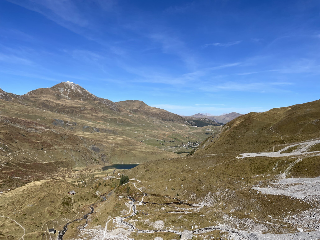 Kurz nach dem See erreicht man eine eindrückliche, steil abfallende Geländestufe. Ab hier eröffnet sich der Blick nach Arosa. Die Bergstation der Weisshornbahn und das Restaurant auf dem Weisshorn sind omnipräsent.