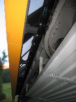 Reifenbeschleuniger und die Schiene des Kettenförderers (links neben den drei Schrauben)