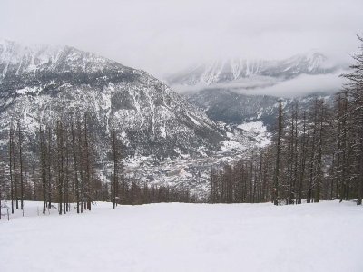 Durch die lichten Lärchenwälder - bei Pulverschnee sicher schöner Treeskiing-Bereich - sieht man schon die ganz schön große Stadt