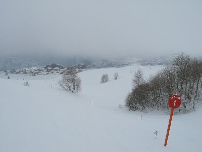 Letzte Markierung der &amp;quot;Canyon&amp;quot; bei der Ausfahrt auf die große Hochalm von Huez. Das große Gebäude gehört zum Bergers-Viertel