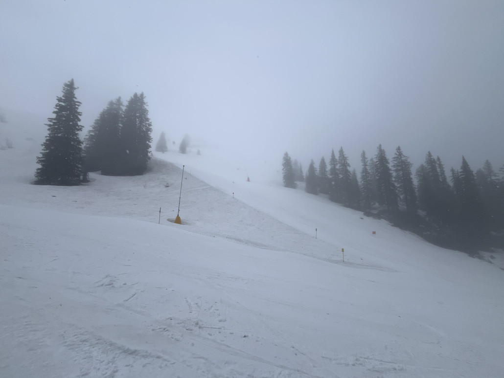 Weiße Bänder zwischen braunen Schneefeldern