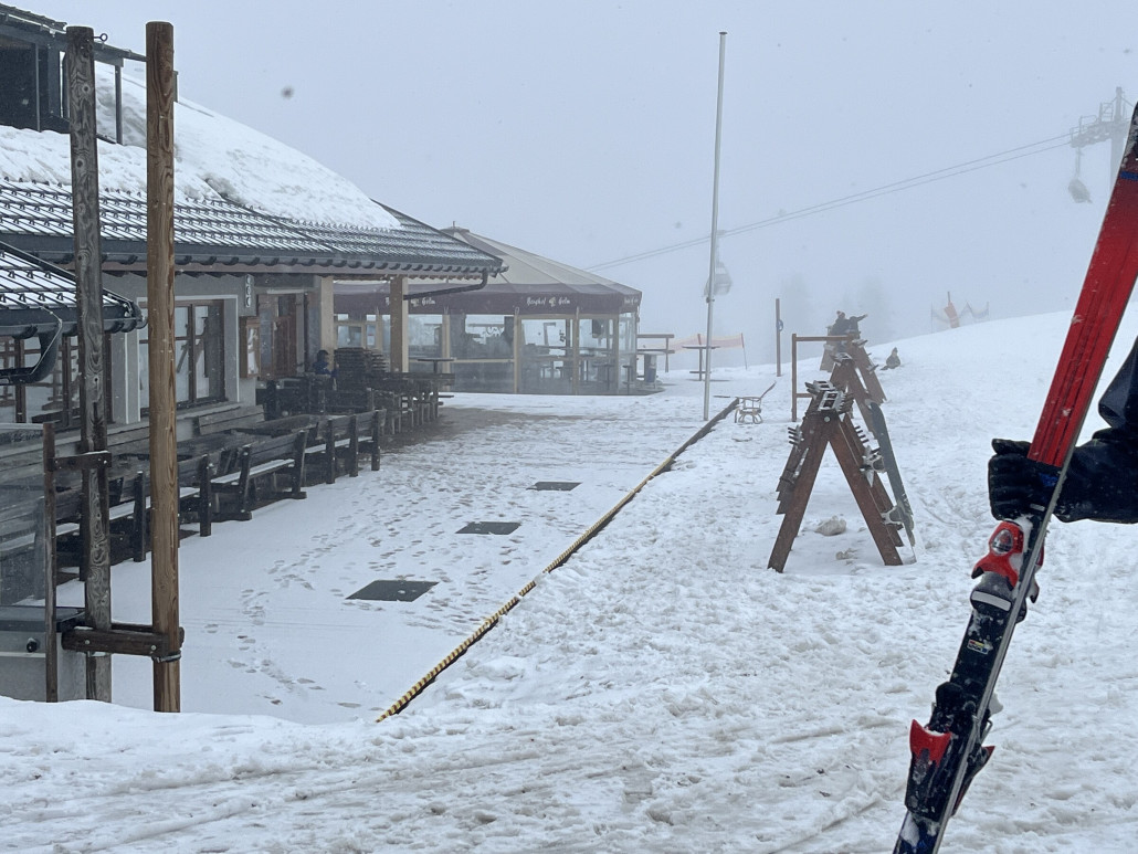 Am Berghof ist es leer wie nie. Einige Fußgänger haben sich hin verirrt, die Gondel hat sie direkt ausgespuckt. Ein einzelnes Snowboard lehnt an den Skiständern. Wer geht denn auch bei dem Wetter raus?