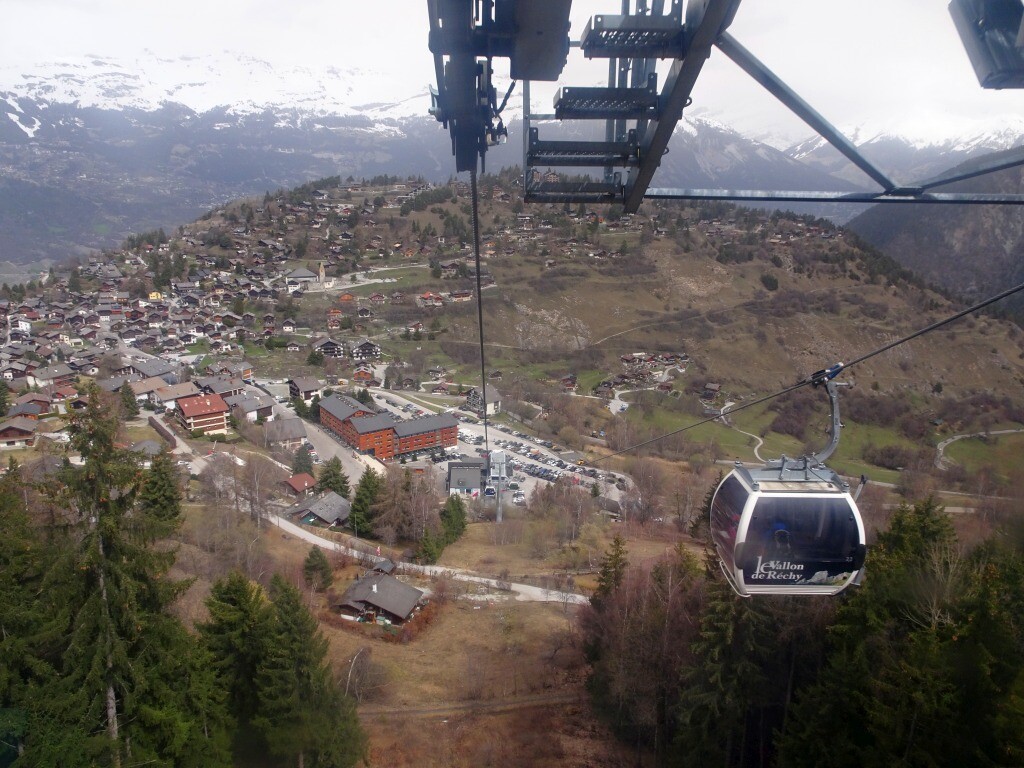 Ohne jegliche Wartezeit ging es mit der 10er Gondelbahn hinauf. Der Parkplatz war ziemlich voll. Unten sieht man Vercorin und auch das Swisspeak Resort direkt neben der Talstation.