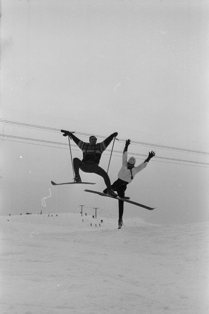 Die beiden Tausendsassas Roger Staub (rechts) und Toni Sailer 1964 beim Looping am Tschuggen bei Aufnahmen für einen Fernsehfilm. Im Hintergrund die Seile der Weisshornbahn 1 und der Skilift Prätschli (Tomeli). Bildnachweis und Lizenz: ETH-Bibliothek Zürich, Bildarchiv / Fotograf: Comet Photo AG (Zürich) / Com_L13-0003-0002-0007 / CC BY-SA 4.0