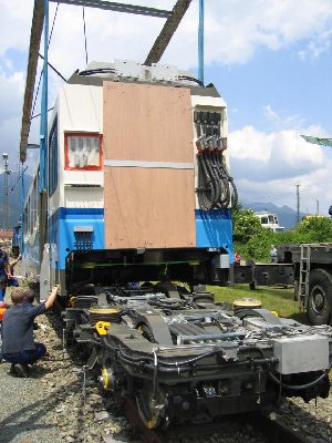 Die eine Hälfte wird auf das Drehgestell aufgesetzt. Noch verdeckt die Holzwand den Durchgang... Die neue Doppeltriebwagen sind miteinander verbunden.