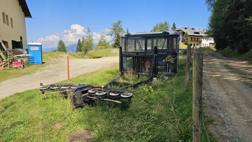 Kabinen und Laufwerke stehen neben der Mittelstation im Gras.