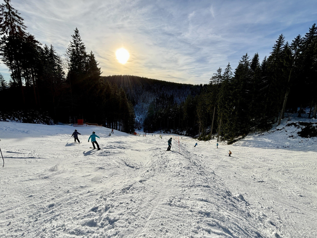 Unten diese massive Kante, links der Pistenpfosten liegt Maschinenschnee und rechts die Fläche hat nur Naturschnee mit grasigen Stellen dazwischen