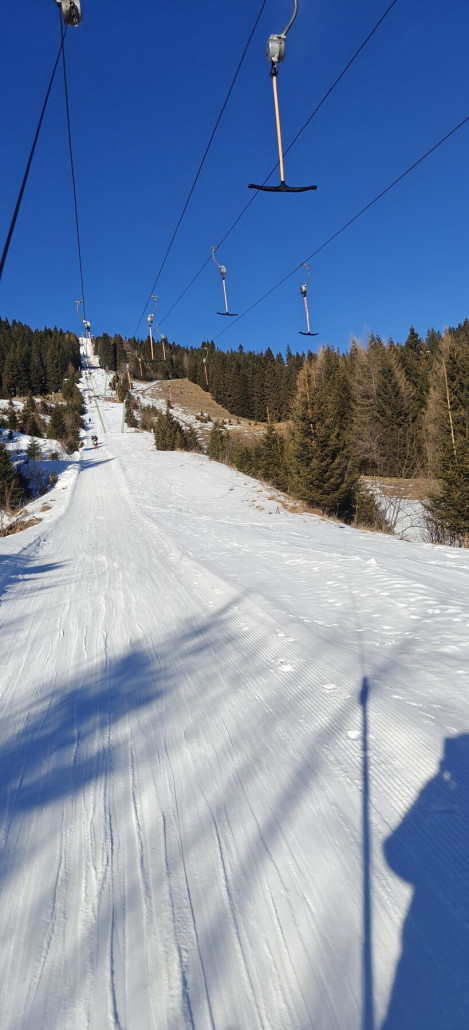 Im Kuhgrabenlift - In Betrieb nur der linke, der Rechte ist nicht mal die Trasse beschneit oder gewalzt. Daneben die Naturschneepiste 6 oder doch besser "Naturgras?"