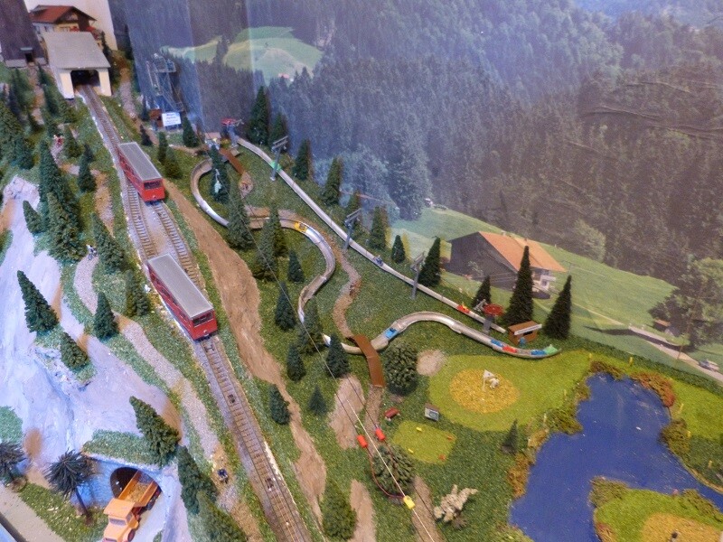 Rechts der Hündlebahn befindet sich der Buchenegglift (den gibt es in Wahrheit natürlich nicht) mit einer Sommerrodelbahn. Der Buchenegglift zieht die Schlitten der Sommerrodelbahn nach oben. Zwischen der Sommerrodelbahn und der Hündlebahn befindet sich noch als weitere Attraktion eine Zipline. Ein Bikepark rundet das Sommerangebot am Hündle noch weiter ab. Bikepark, Zipline und Sommerrodelbahn waren mal wieder gute Ideen von User Phil 80, mit dem ich mich regelmäßig über Modellbau austausche. Danke Philip!