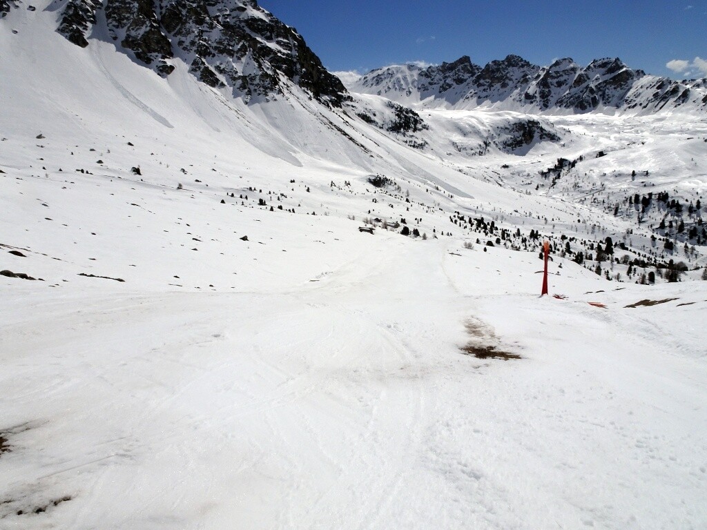 Die Piste wurde gerade geschlossen, die Pistenstöcke stehen schon gebunden am Rand. Kurz etwas weniger Schnee.