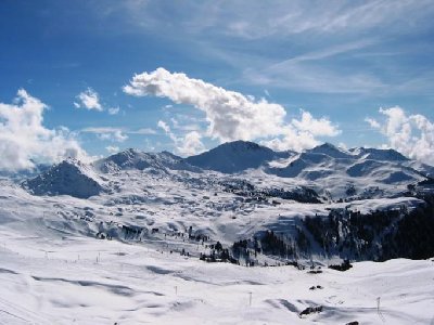 Blick von der Bergstation 4 SB Crozats auf das Kerngebiet von La Plagne mit der Grande Rochette (zweiter Gipfel von links) und dem Roc de Becoin (dunkel, in der Mitte). Die weitläufigen flachen Almwiesen der Bildmitte haben dem Gebiet seinen Namen gegeben