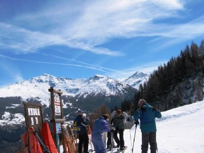 Hier der Abzweigungswegweiser bei Soillet. Hinten das Skigebiet von St. Foy en Tarantaise, ein echter Geheimtipp. Die Szenerie hat sich auch gewandelt. Statt Gletscher und luftiger Felspassagen nun steiler Wald und &amp;quot;Hinabtauchen&amp;quot; fast bis zur St